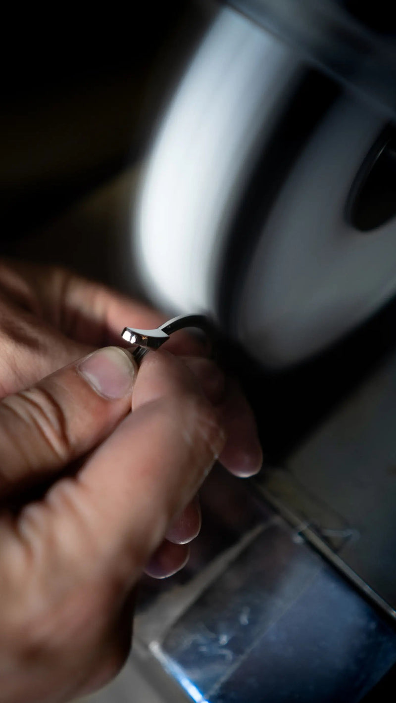watchmaker polishing a component for a trilobe watch